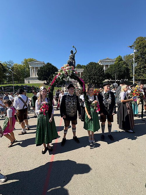 Das Bild zeigt die Schützenkönige auf dem Oktoberfestgelände bei der Ankunft. Im Hintergrund die Bavaria.